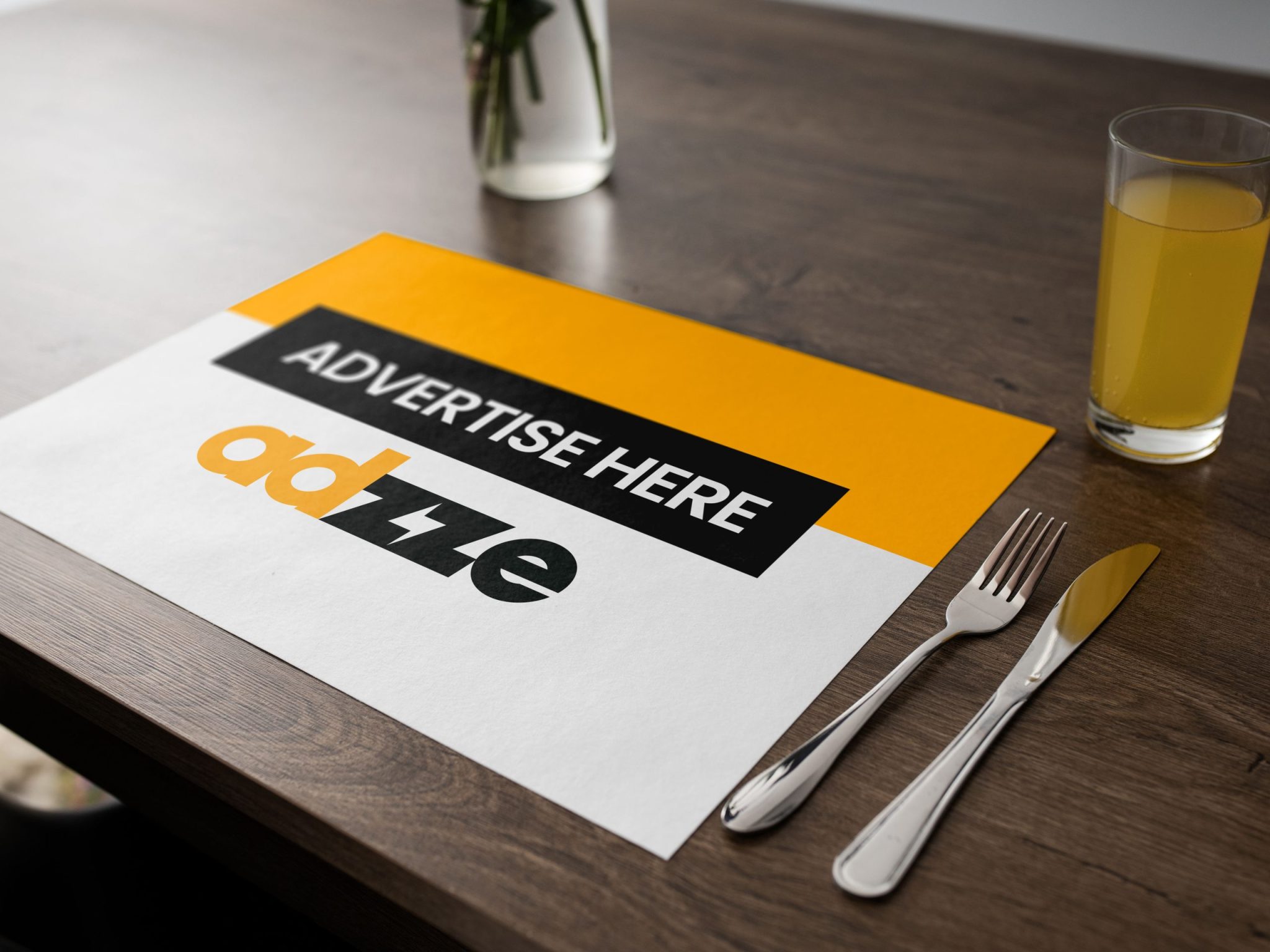 The image shows an Adzze's advertising placemat on a table next to a fork and a knife